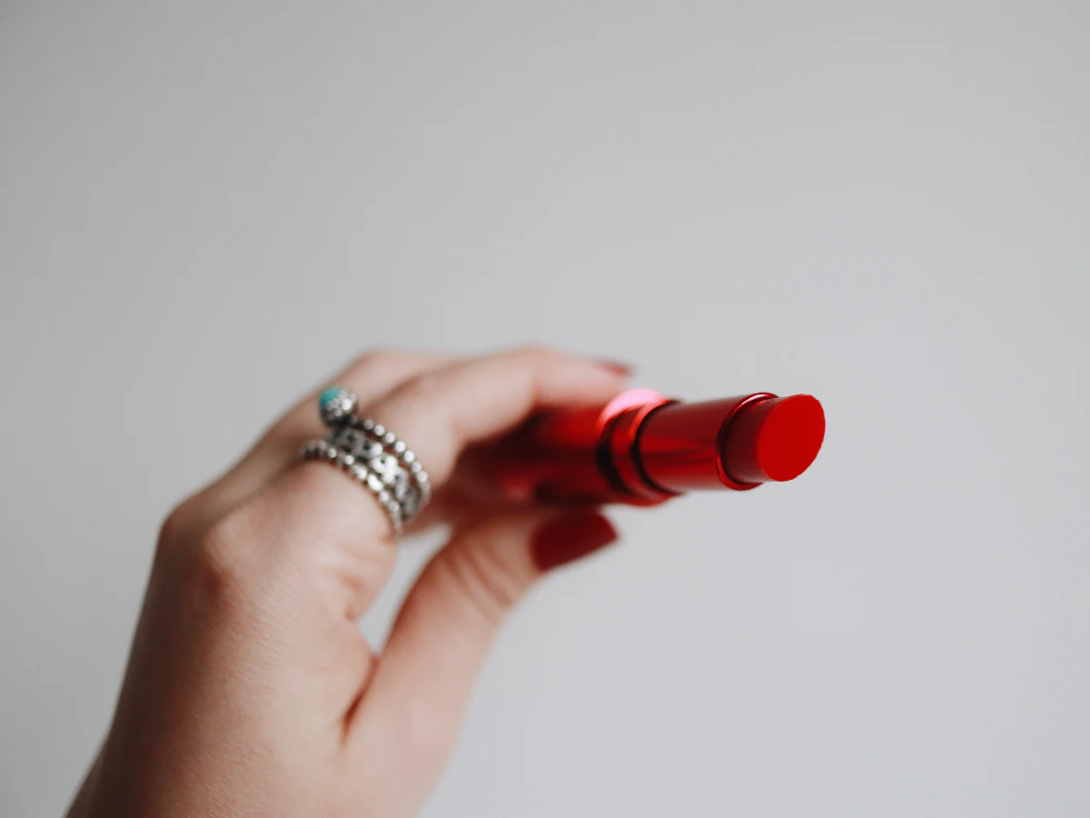 Lip and base swatches being compared on a customer's hand