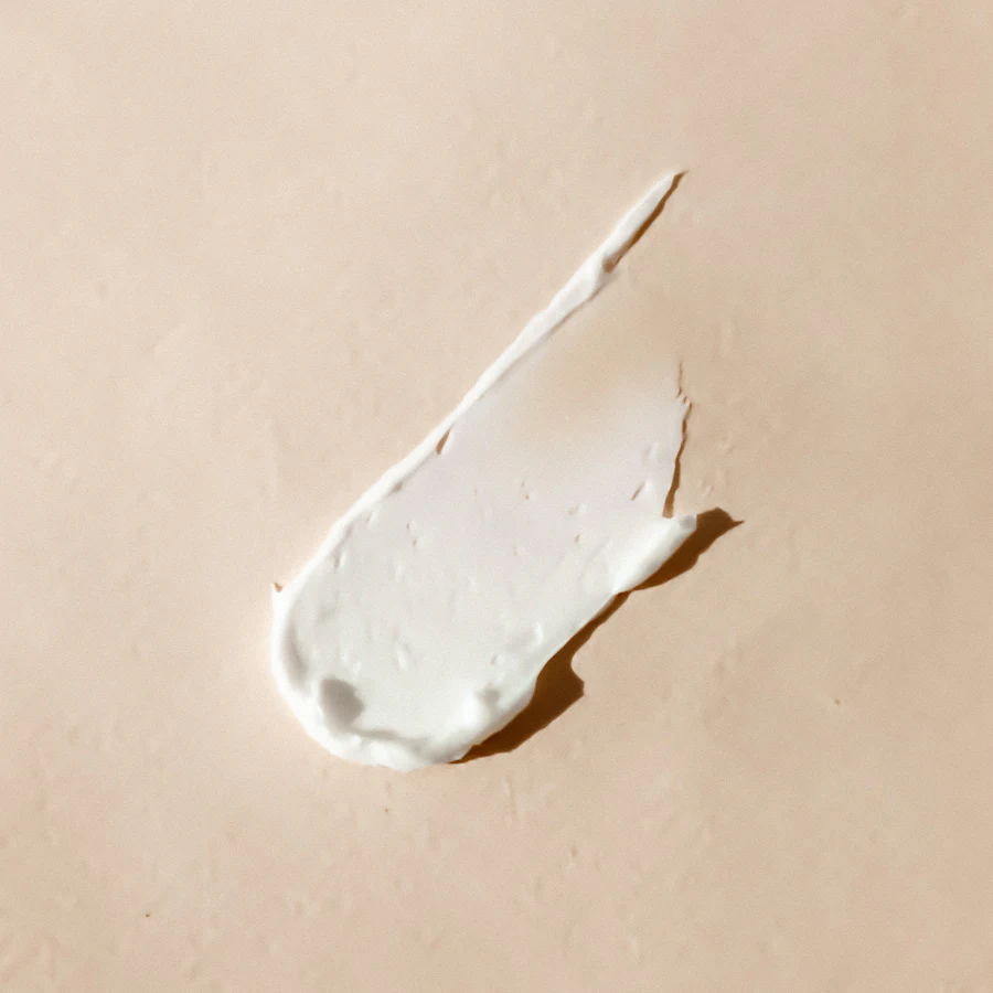 A smear of white balm on a beige background