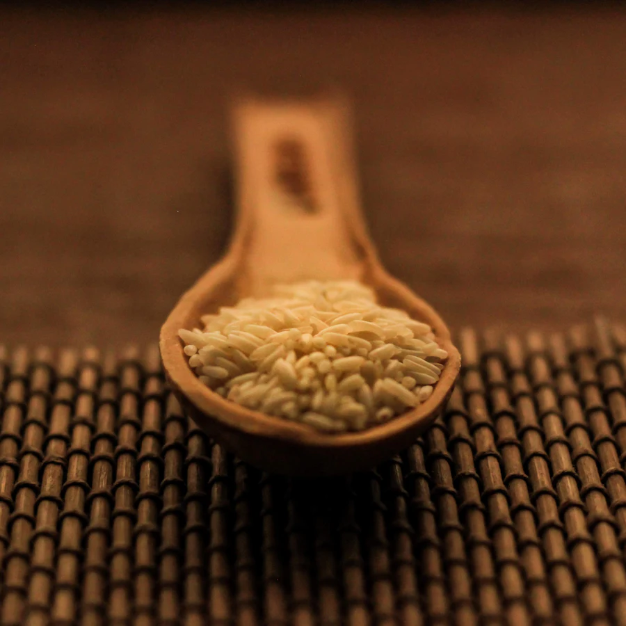 Uncooked rice on a wooden spoon