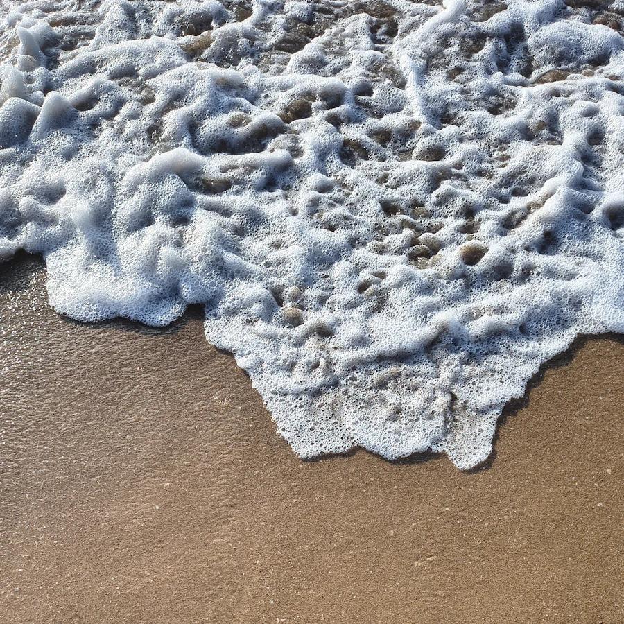 White sea foam on sand