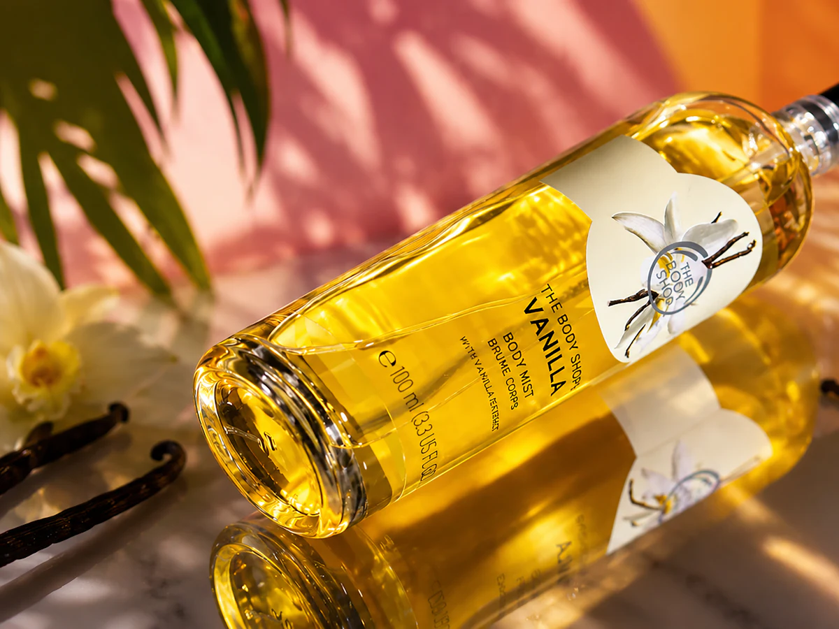 A body mist bottle with vanilla pods and orchids
