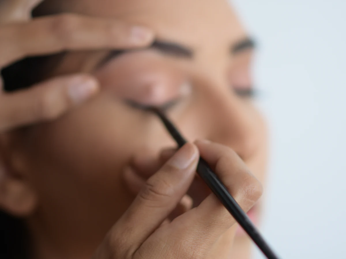 Filling in a brow with a fine pencil