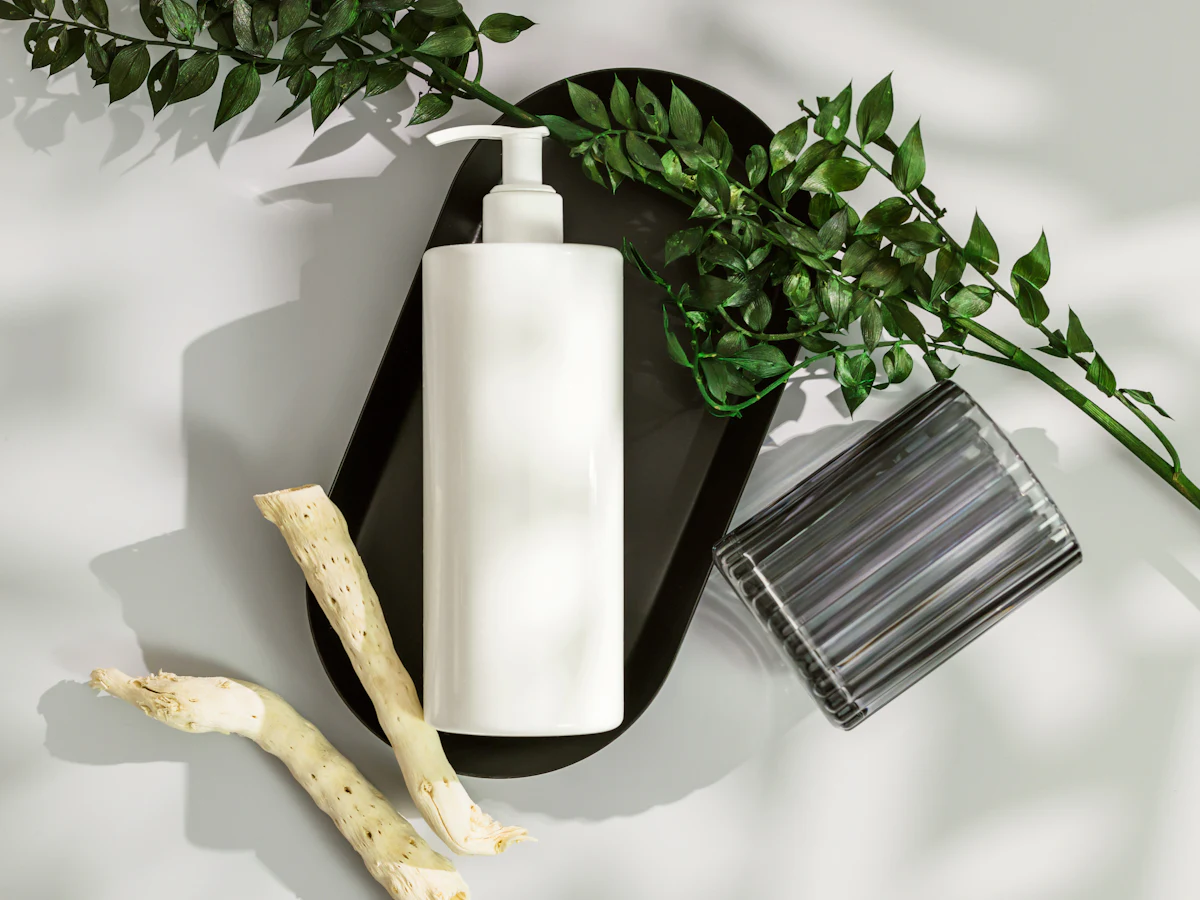 A pump bottle of scalp shampoo with green leaves