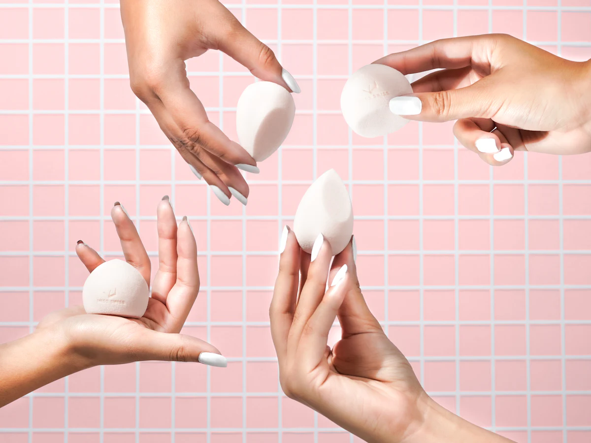 Hands holding white blending sponges