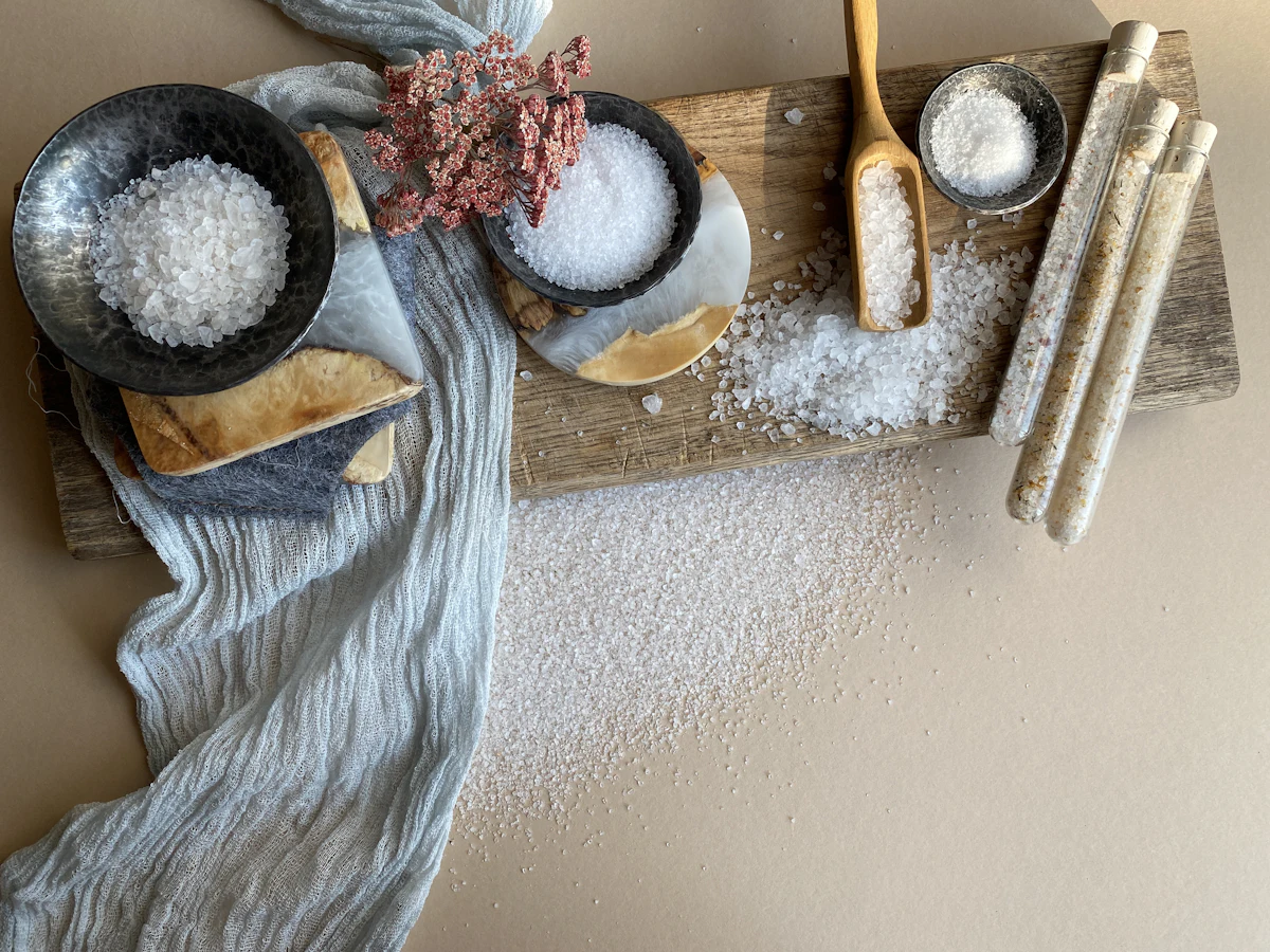 Salt and herbal body scrub ingredients on wood