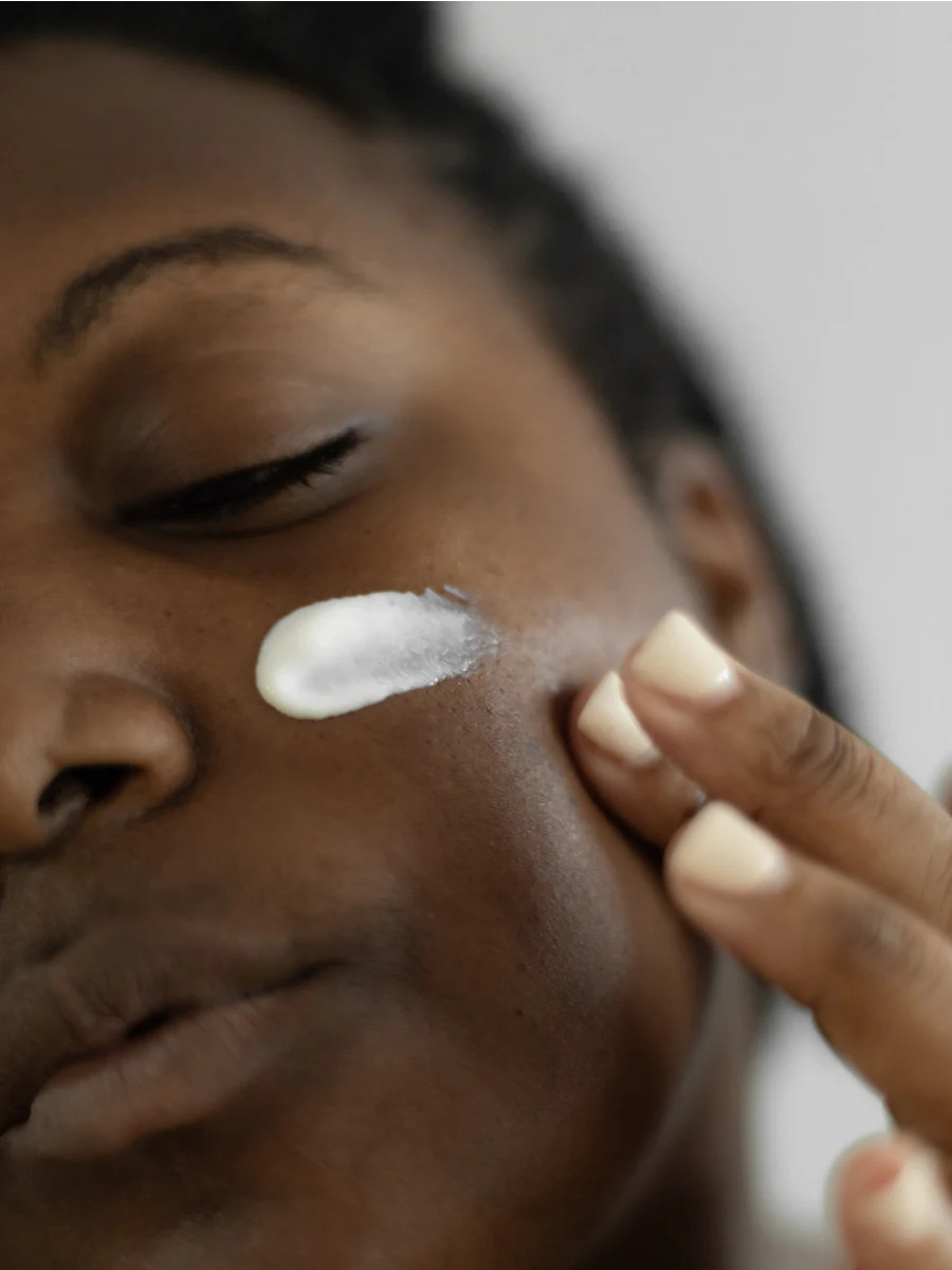 Applying sunscreen generously across the cheek